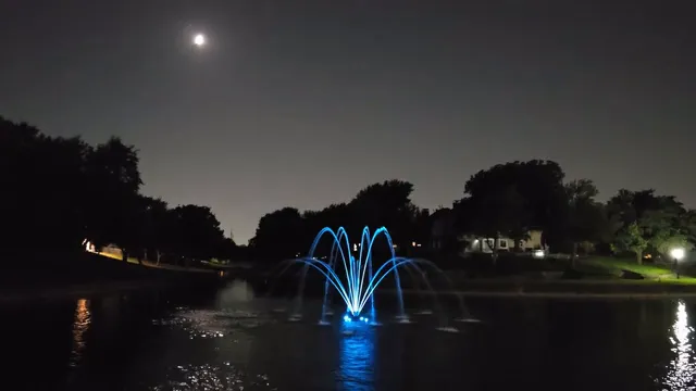 Horizontal video: A fountain is lit up at night with the moon in the background 27775829. Duration: 34 seconds. Resolution: 1920x1080