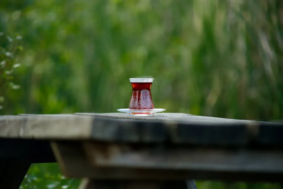 Scenic Outdoor Tea Glass on Rustic Picnic Table