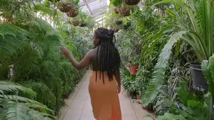 Horizontal video: A woman touching the leaves of the plants in a green house 3251845. Duration: 11 seconds. Resolution: 3840x2160