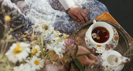 Horizontal video: A woman is holding a cup of tea on a table 4974803. Duration: 29 seconds. Resolution: 4096x2160