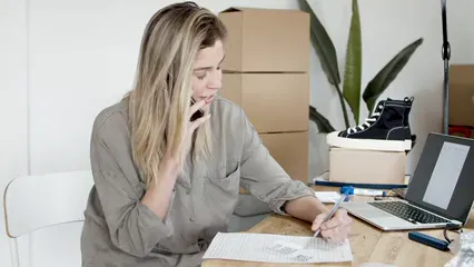 Horizontal video: Woman writing orders while on the phone 7287516. Duration: 16 seconds. Resolution: 3840x2160