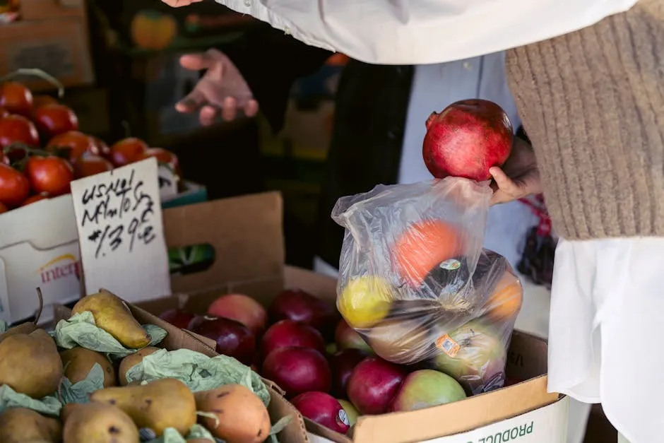 Crop woman choosing assorted healthy fruits in street market