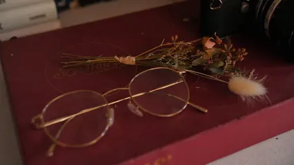 Horizontal video: Dried flowers beside an eyeglasses 8997556. Duration: 8 seconds. Resolution: 1920x1080