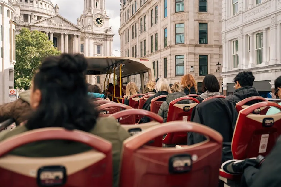 A group of tourists enjoying a ride on a double-decker bus with views of London landmarks.