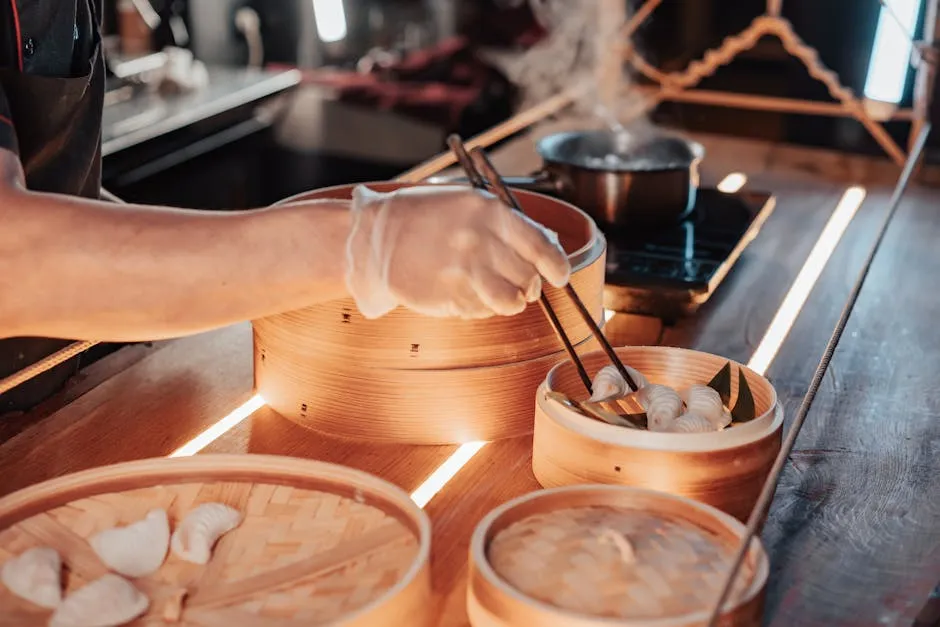 Close-up of a chef using chopsticks to place dumplings in a bamboo steamer.