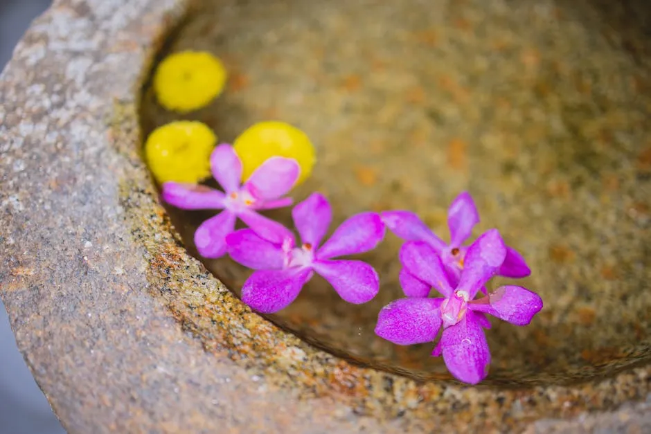 From above of crystal clean transparent water with purple gentle orchid and bright yellow flowers